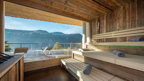 Een houten interieur met een balkon met uitzicht op bergen.