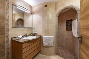 A bathroom with a sink, mirror, and towel rack.