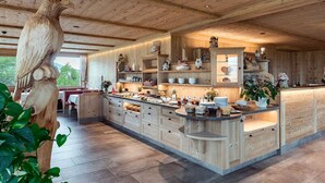 Une cuisine spacieuse avec des meubles en bois, un îlot central et un grand plafond en bois.