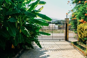 A gated entrance with a paved pathway leading to a building.