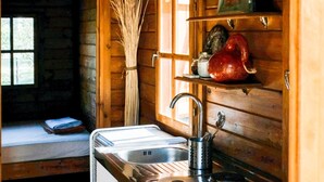 A compact kitchen with a sink, stove, and wooden cabinets.