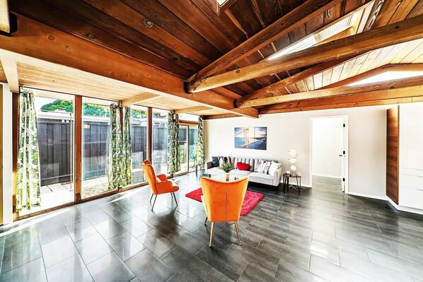 Relax in a spacious living area with a high ceiling and comfortable seating for two.