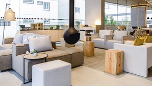 Una sala de estar moderna con un conjunto de sofá, una mesa de centro y una lámpara colgante grande.