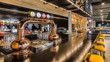 A modern bar area with a copper tap system, a bar counter, and seating.