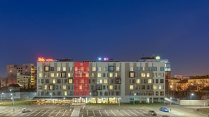 Un hotel de varios pisos con un llamativo cartel rojo que anuncia un nuevo comienzo.