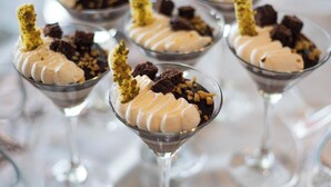 Dessertbekers in martini-glazen met slagroom en chocoladestukjes.