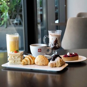 Ein Tisch mit verschiedenen Backwaren, einer Kaffeetasse und einem Dessertteller.