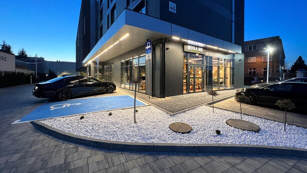 Un edificio moderno con un restaurante llamado "BONAME" en la entrada.
