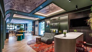 Een modern interieur met een bar, zitplaatsen en een groot televisiescherm.