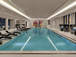 Una piscina techada, sillones reclinables de piscina