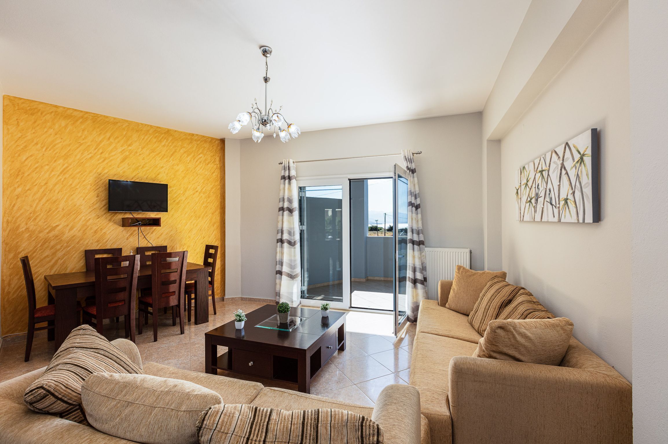 A living room with a sofa, coffee table, TV, and dining area.