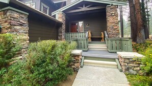 A house with a stone facade, a porch with wooden railings, and a number '1043' on the wall. - Pet-Friendly, Stunning! On Golf Course! Private Hot Tub, Grill, Washer/Dryer (Mammoth Lakes)