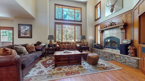 A spacious living room with a fireplace, large windows, and a cozy seating area. - Pet-Friendly, Stunning! On Golf Course! Private Hot Tub, Grill, Washer/Dryer (Mammoth Lakes)