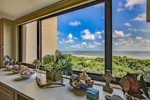 Enjoy a serene coastal view from the large window, surrounded by decorative items and a minimalist design.