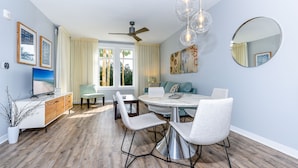 Un espace repas moderne avec une table ronde, quatre chaises et un ventilateur de plafond.