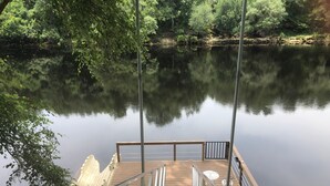 A wooden dock extending into a calm lake, surrounded by trees.