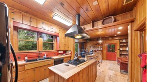 Una cocina amplia con armarios de madera, una isla central y un ventanal grande.