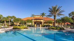 A resort with a large pool, palm trees, and a building with a red-tiled roof. - 483-Stunning 6-Bed Home w/ Private Pool, Quiet Conservation View (Davenport)
