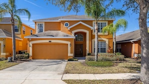 A two-story house with a garage, a front porch, and a well-maintained lawn. - 483-Stunning 6-Bed Home w/ Private Pool, Quiet Conservation View (Davenport)