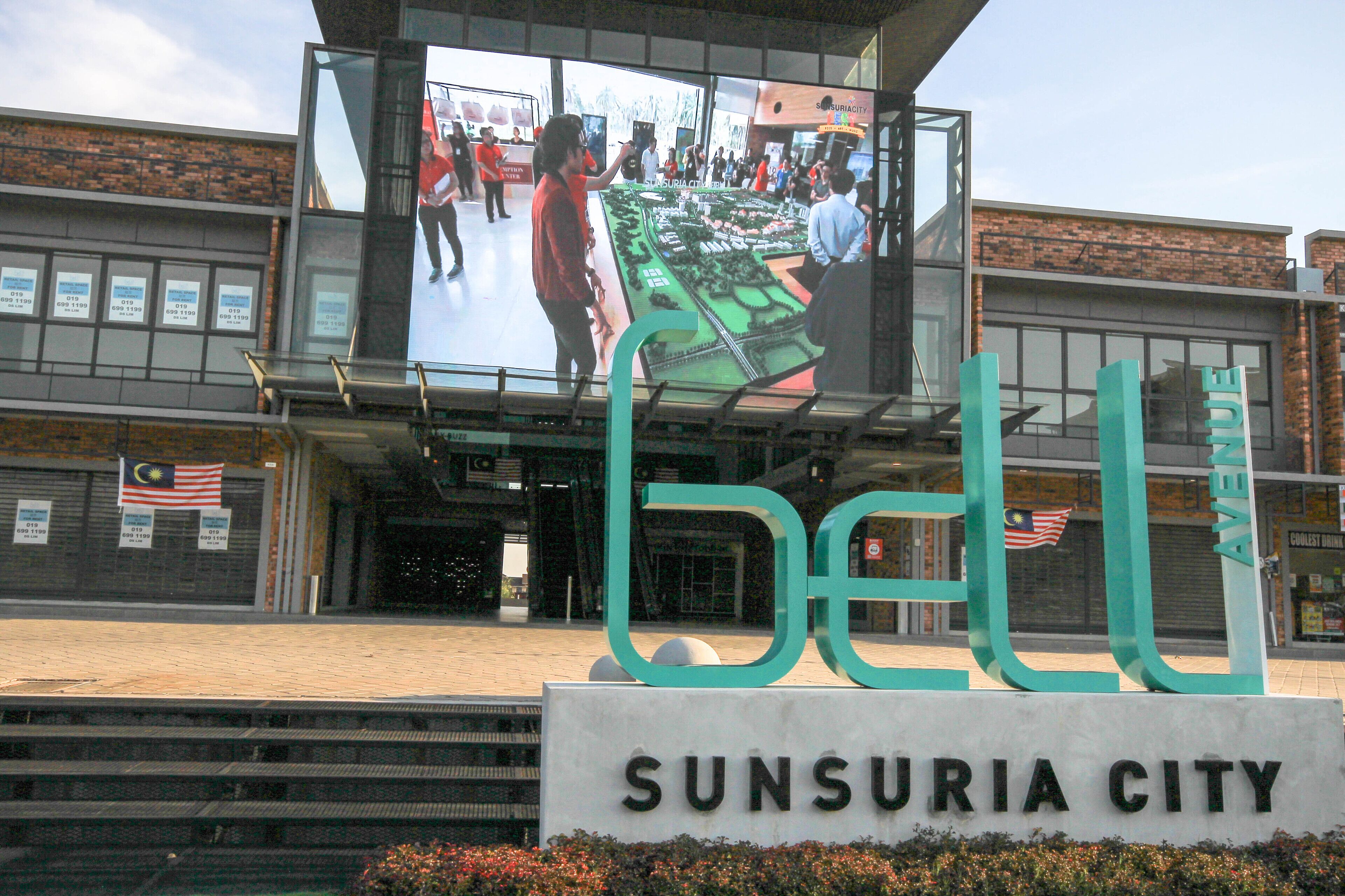 Une enseigne indiquant « Sunsuria City », avec un grand chiffre « 6 » et le mot « Avenue » écrit au-dessus.