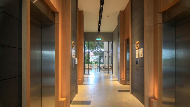 A modern hallway with wooden accents and a glass door leading to an outdoor seating area.