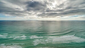 A panoramic view of a calm sea under a cloudy sky.
