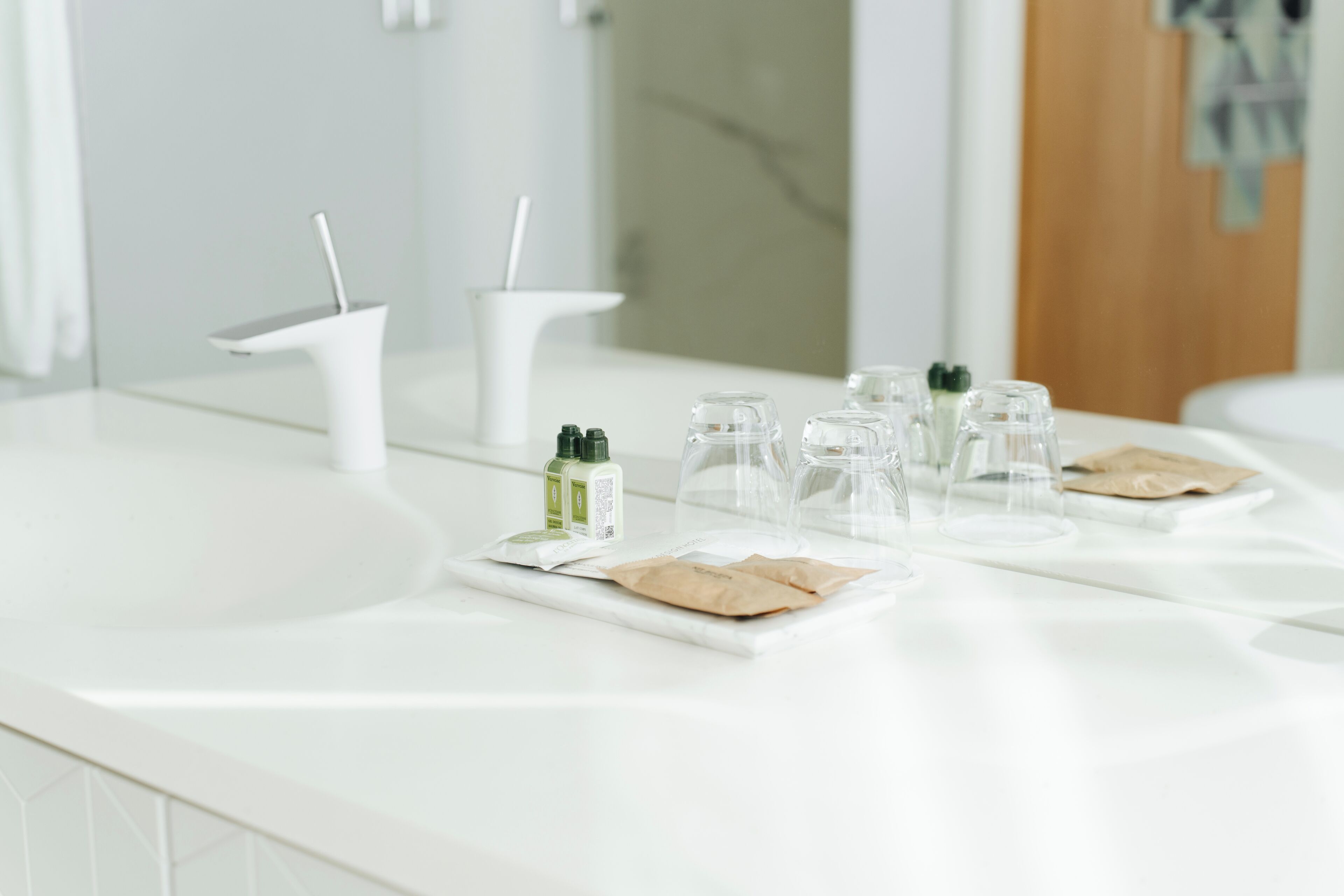 Un bagno moderno con un piano d'appoggio bianco, uno specchio e un lavandino.