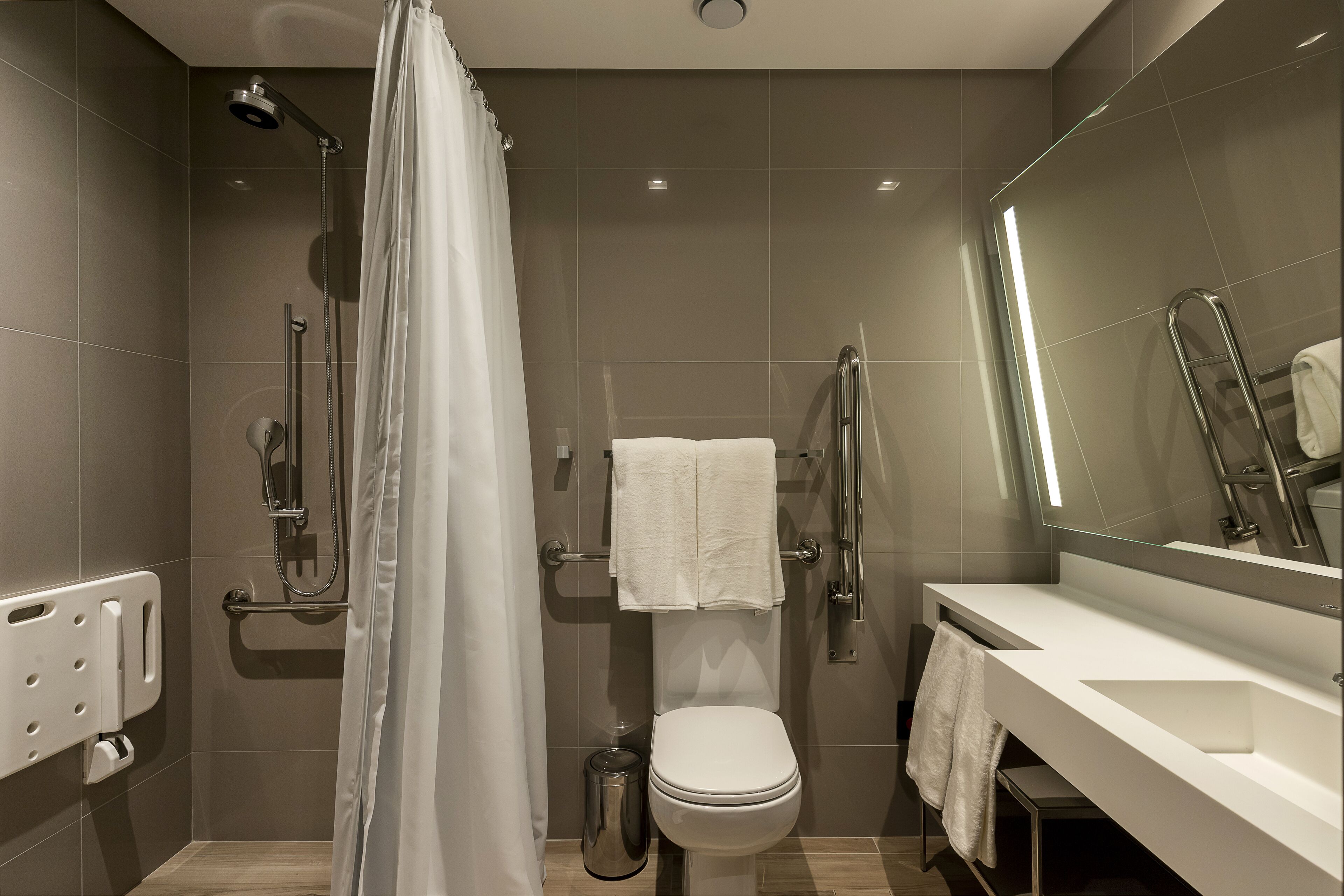 Un baño moderno con ducha, inodoro y lavamanos.