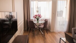 A dining area with a glass table, chairs, and a vase of flowers. - Apartament plaża 41 bros (Gdansk)