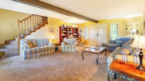 A living room with a staircase, a bookshelf, and a door. - Lake Reunion location, private dock/slip/lily pad. 3 acres, hiking, fire pit, walk to Bagnell Dam (Lake Ozark)