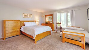 A bedroom with a wooden bed, a wooden dresser, a chair, and a small table. - Lake Reunion location, private dock/slip/lily pad. 3 acres, hiking, fire pit, walk to Bagnell Dam (Lake Ozark)