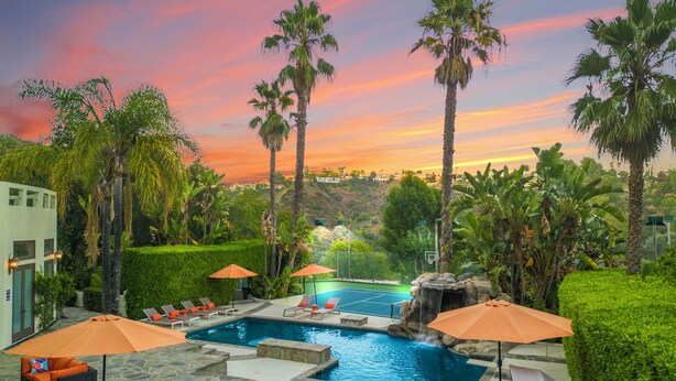 A pool area with multiple pools, lounge chairs, and umbrellas.
