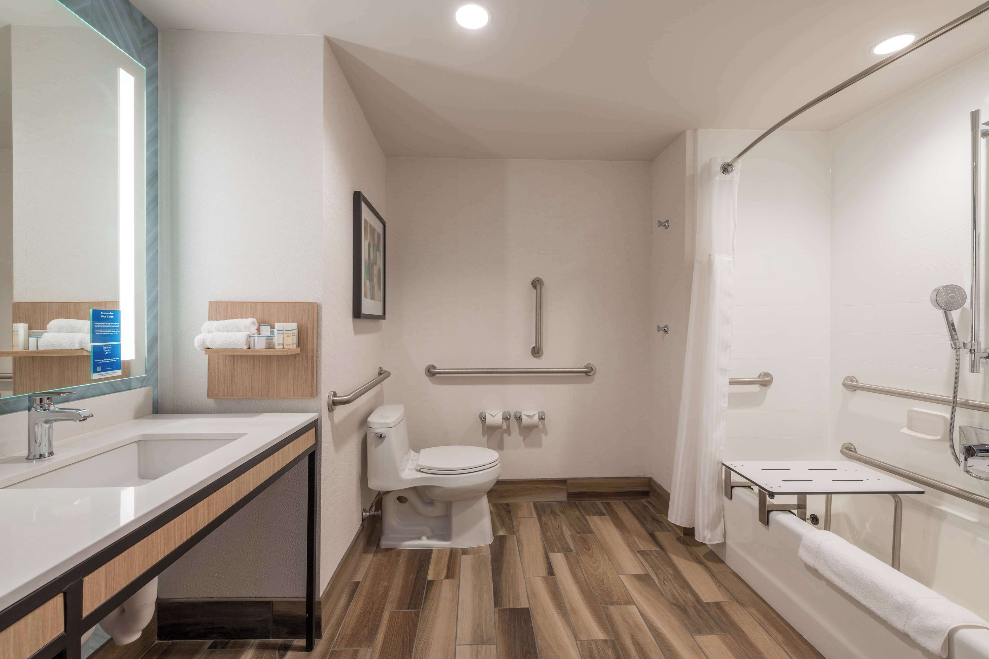 A modern bathroom with a sink, toilet, and shower area.