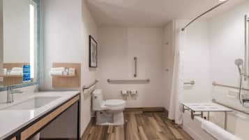 Un baño moderno con lavabo, inodoro y zona de ducha.