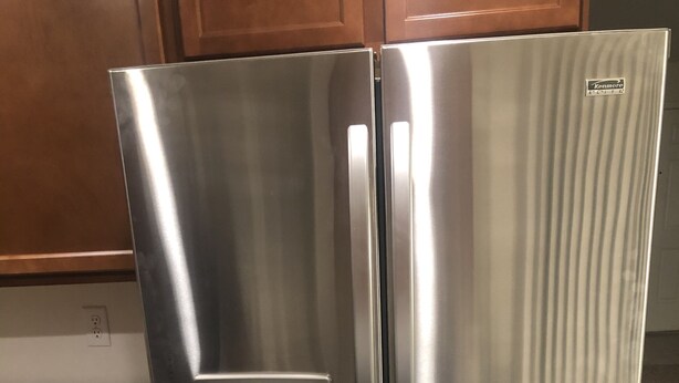 A stainless steel Kenmore Elite refrigerator with a built-in ice maker, located in a kitchen with wooden cabinets and granite countertops. - Newly built property (Bakersfield)
