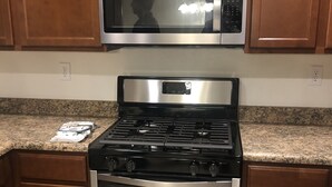 A kitchen with a stainless steel stove, oven, and microwave. - Newly built property (Bakersfield)