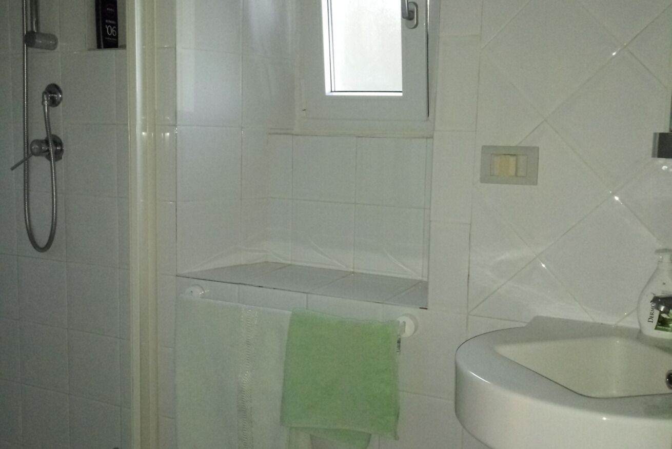 A bathroom with a shower, a sink, and a mirror.