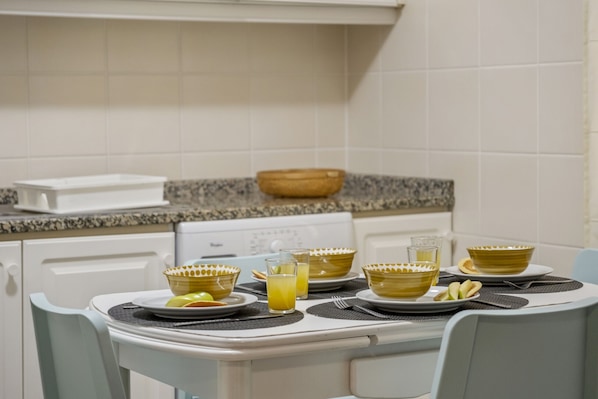 A dining table set with yellow bowls, plates, and glasses of orange juice.