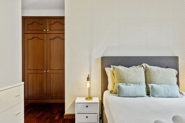 Ein Schlafzimmer mit Bett, Nachttischlampe und Kleiderschrank.
