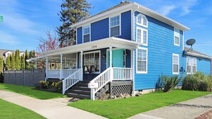 A two-story house with a porch, a satellite dish, and a mailbox.