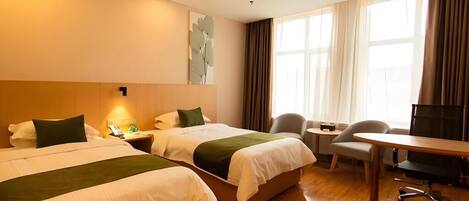 A hotel room with two beds, a desk, a chair, and a TV.