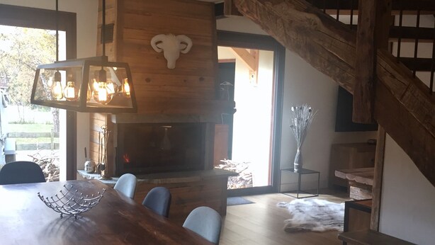 A dining area with a large wooden table, chairs, and a hanging light fixture. - ANCELLE Chalet-style house 160 m2 at the foot of the slopes (Ancelle)