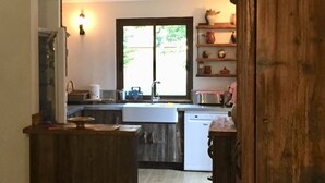 A kitchen with wooden cabinets, a sink, and a window. - ANCELLE Chalet-style house 160 m2 at the foot of the slopes (Ancelle)