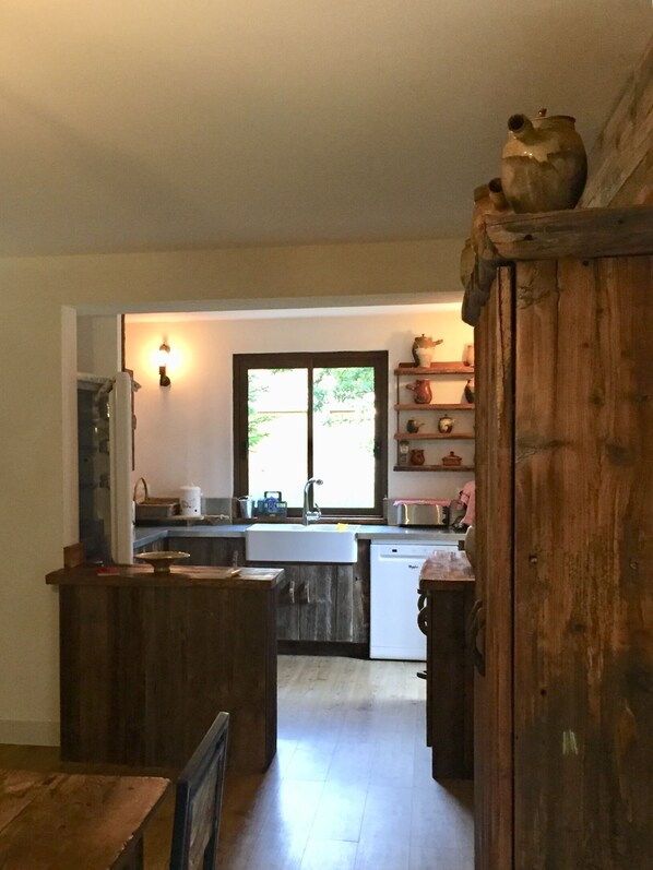 A kitchen with wooden cabinets, a sink, and a window.