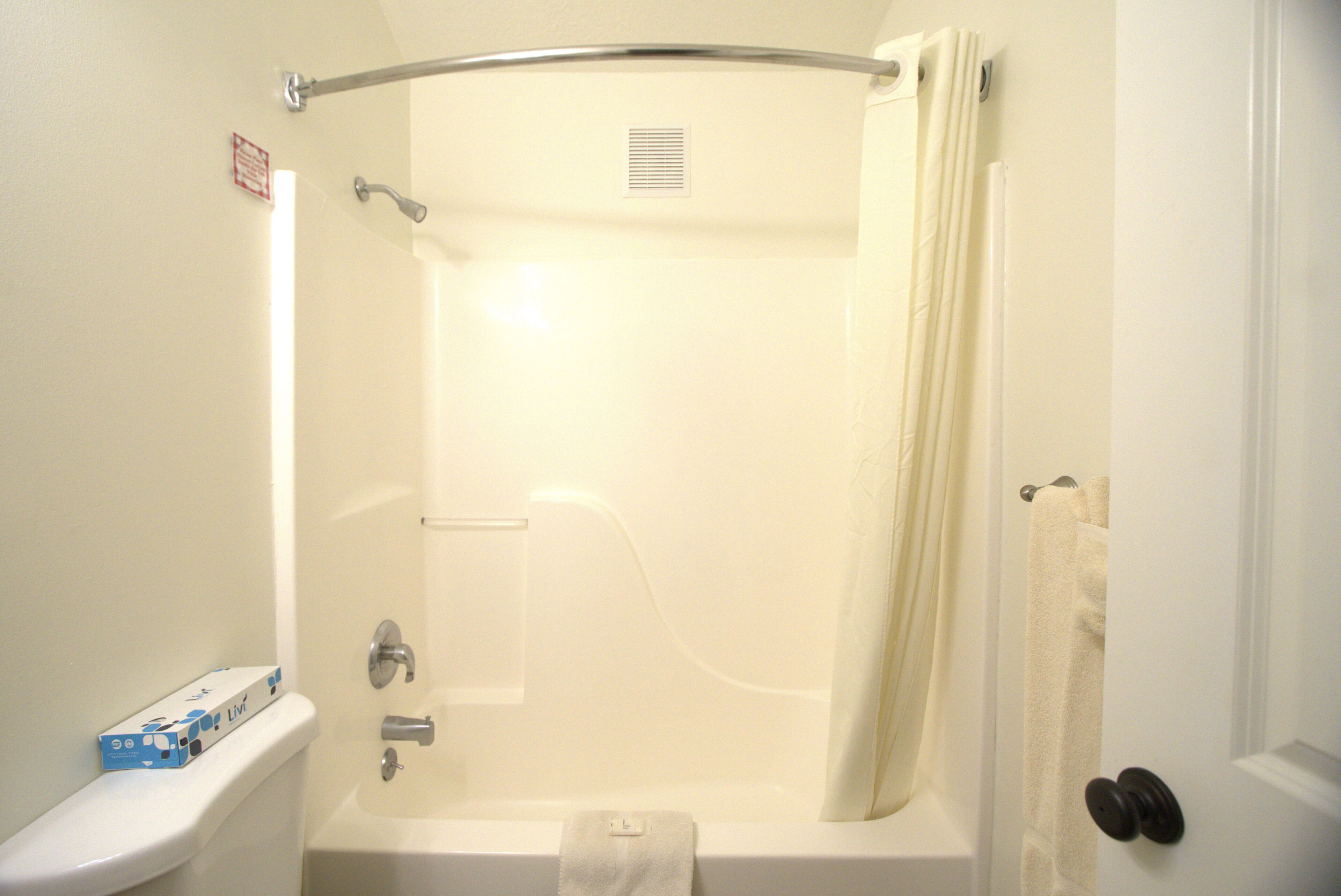 Un baño con bañera, inodoro y un perchero para toallas.