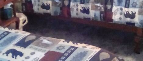 Een slaapkamer met twee bedden, elk met een quilt met een patroon.