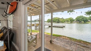 Ein überdachter Außenbereich mit Blick auf einen See, einen Steg und ein Pavillon.