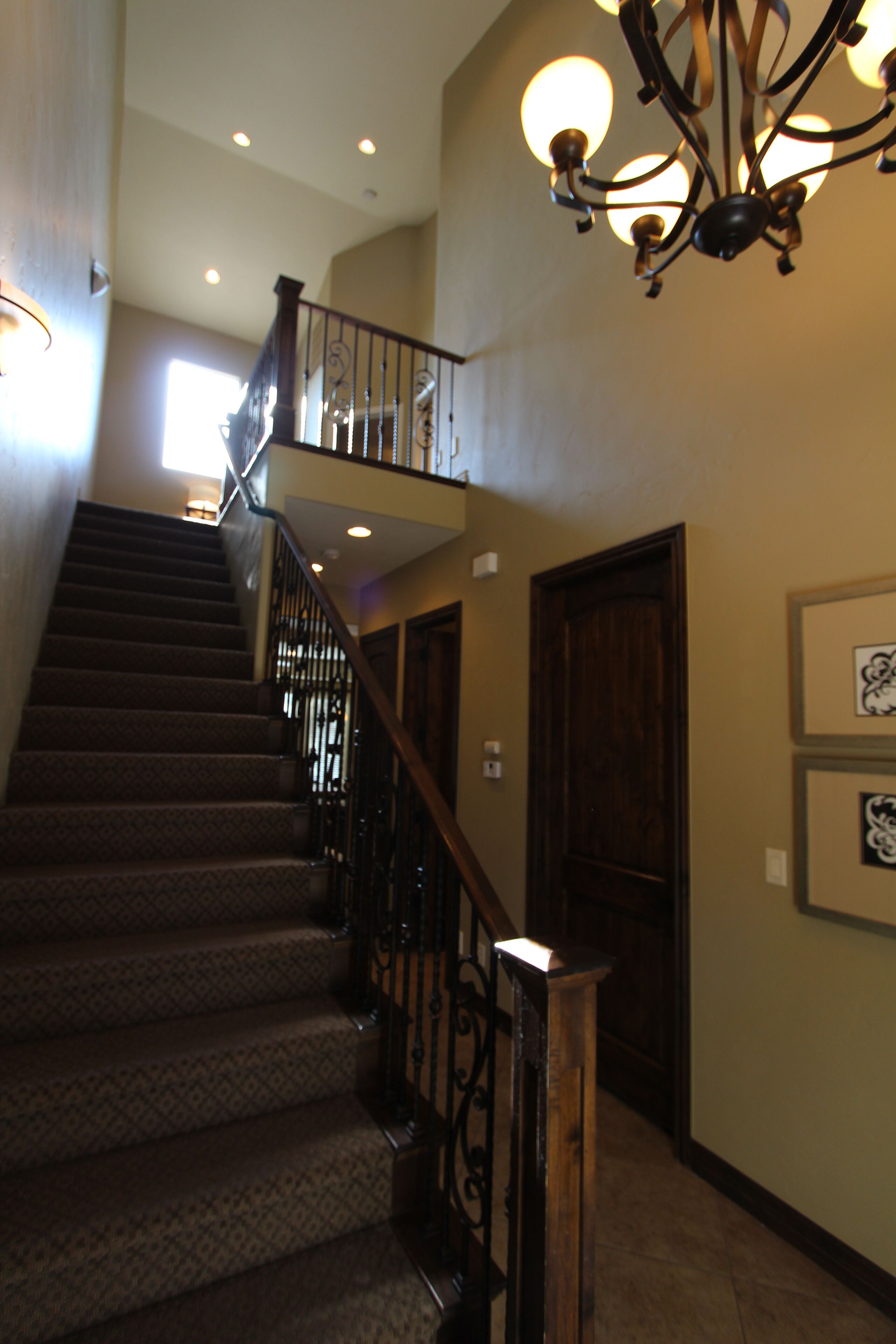 A staircase with a wooden railing and carpeted steps leading to an upper level.