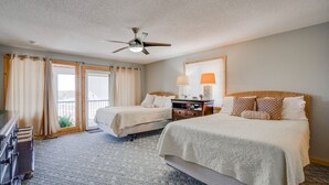 A hotel room with two beds, a ceiling fan, a nightstand with a lamp, and a view of the outdoors. - Private pool vacation home, spa, game rooms, HOA boat slip. (Lake Ozark)