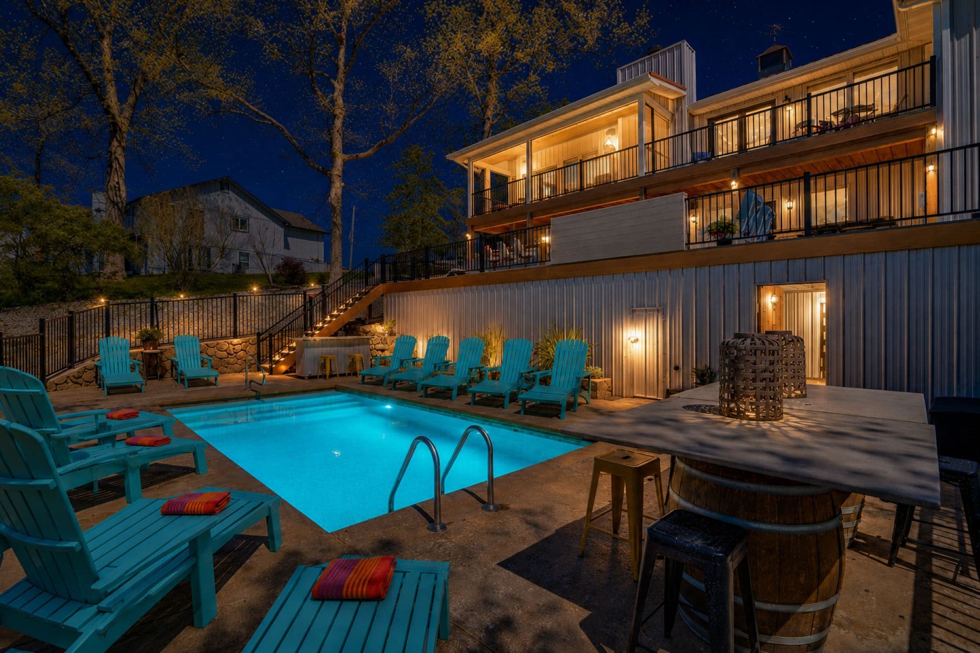 A two-story building with a pool, outdoor seating, and a bar area.